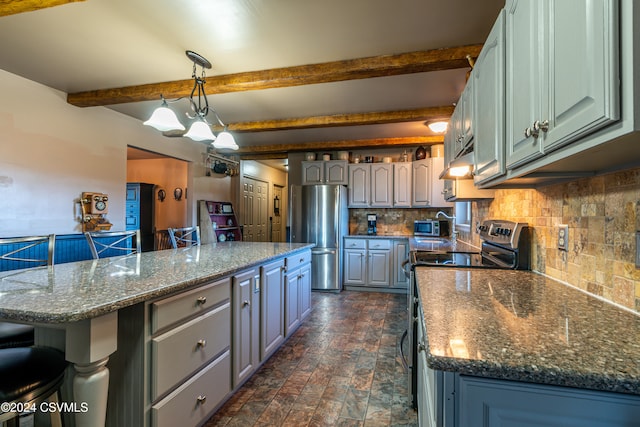 kitchen featuring stainless steel appliances, a kitchen bar, hanging light fixtures, and a kitchen island