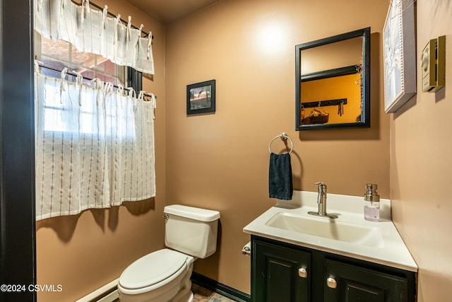 bathroom featuring vanity, a baseboard heating unit, and toilet