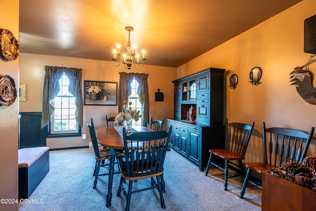 dining area featuring light colored carpet and a notable chandelier