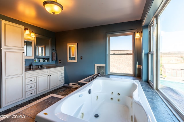 bathroom featuring vanity, tiled bath, and a baseboard heating unit