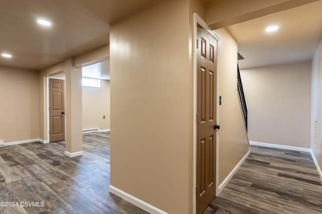 corridor with dark hardwood / wood-style floors and baseboard heating