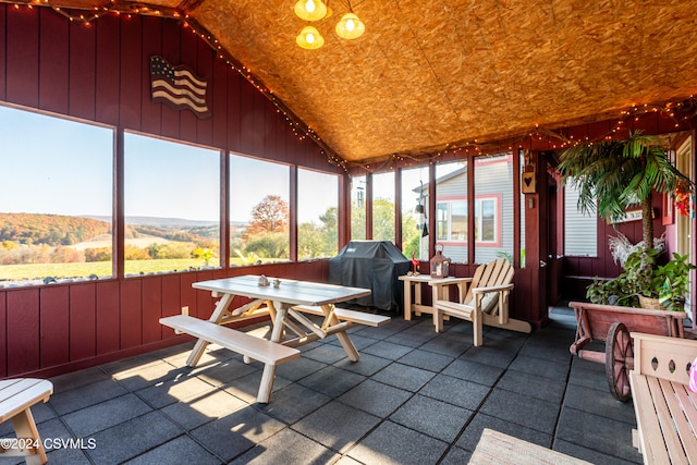 sunroom / solarium with a mountain view, vaulted ceiling, and a wealth of natural light