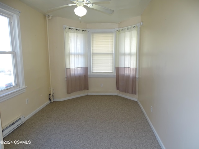 empty room with ceiling fan, light colored carpet, baseboard heating, and a wealth of natural light