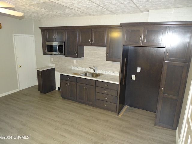 kitchen with light hardwood / wood-style floors, dark brown cabinetry, and sink