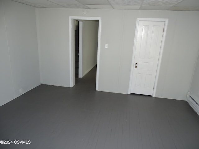 empty room featuring a drop ceiling and dark wood-type flooring