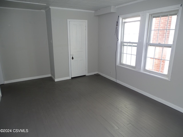 empty room with ornamental molding and dark wood-type flooring