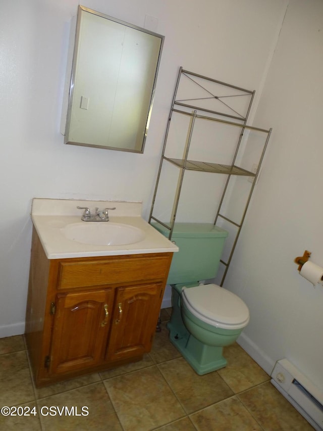 bathroom with vanity, a baseboard heating unit, toilet, and tile patterned flooring