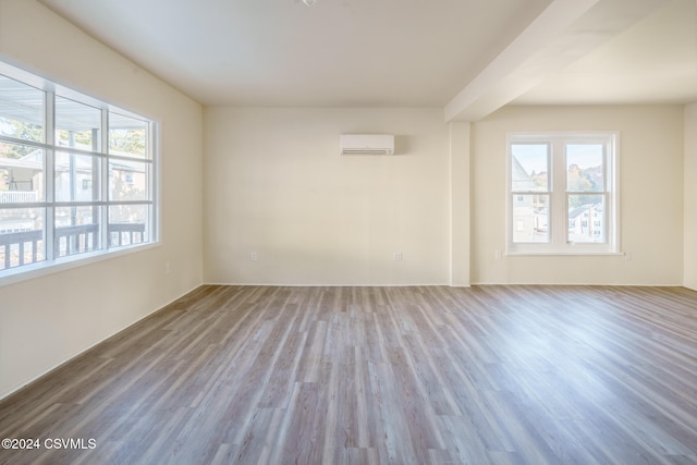 unfurnished room featuring a wall mounted AC and wood-type flooring