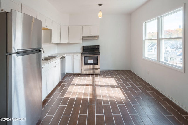 kitchen with white cabinetry, stainless steel appliances, sink, and pendant lighting