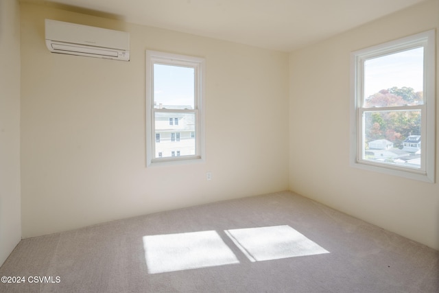 unfurnished room with an AC wall unit and light carpet