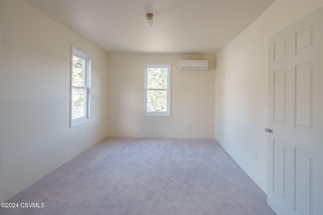 spare room with a wall mounted AC and light colored carpet