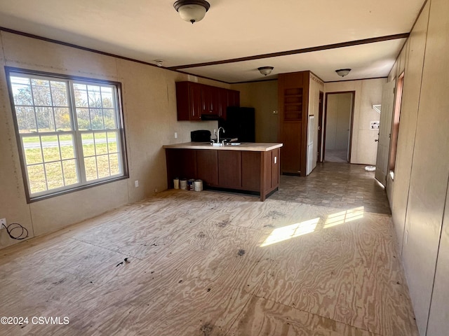 kitchen with sink, kitchen peninsula, and black refrigerator