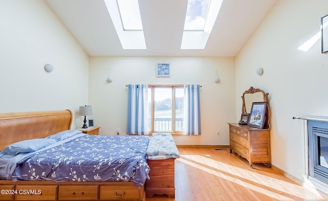 bedroom with light hardwood / wood-style floors and vaulted ceiling with skylight