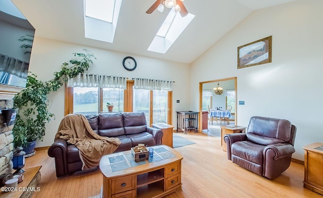 living room featuring light hardwood / wood-style flooring, high vaulted ceiling, and ceiling fan with notable chandelier