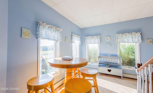 dining room with hardwood / wood-style floors and a baseboard heating unit