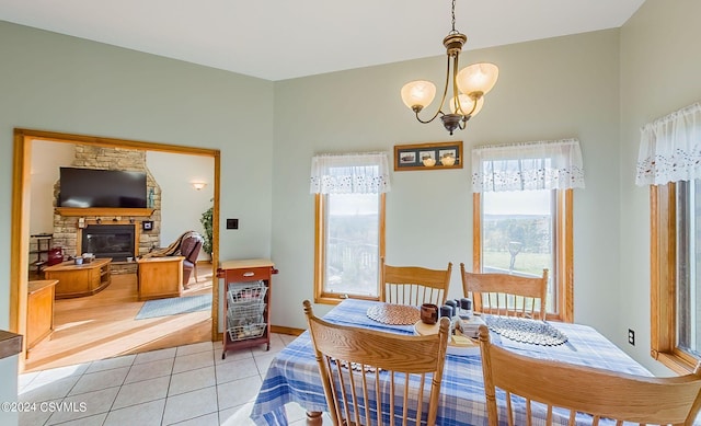 dining space featuring an inviting chandelier, light hardwood / wood-style flooring, and a fireplace