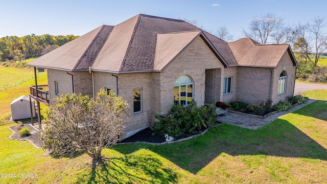 view of side of home featuring a wooden deck and a lawn