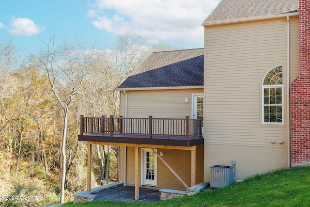 rear view of property with central air condition unit, a shingled roof, and a deck