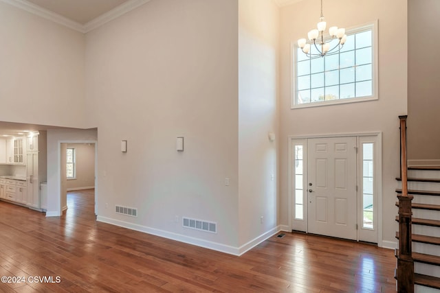 foyer featuring ornamental molding, hardwood / wood-style flooring, and a healthy amount of sunlight