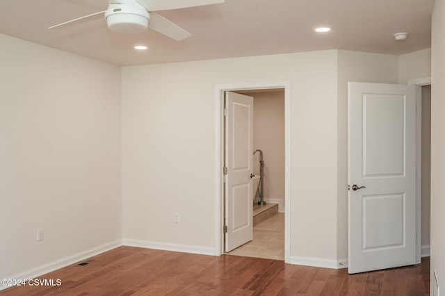 unfurnished bedroom featuring recessed lighting, baseboards, wood finished floors, and visible vents