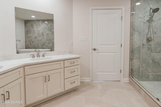 full bath featuring vanity, baseboards, a soaking tub, and a shower stall