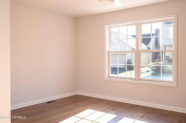 unfurnished room with visible vents, baseboards, ceiling fan, and wood finished floors