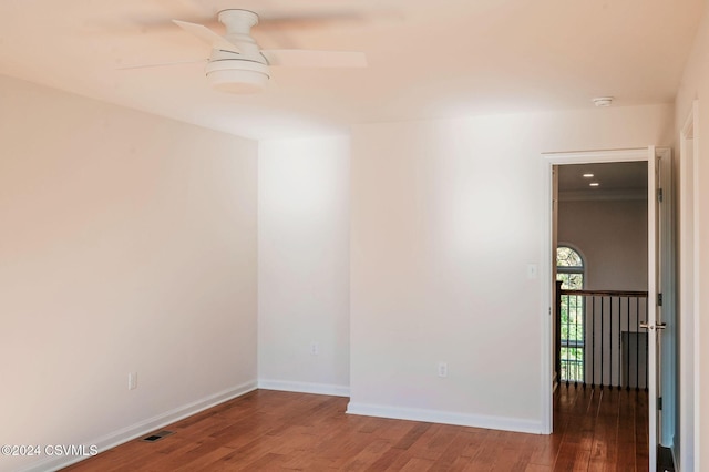 empty room featuring baseboards, ceiling fan, wood finished floors, and visible vents