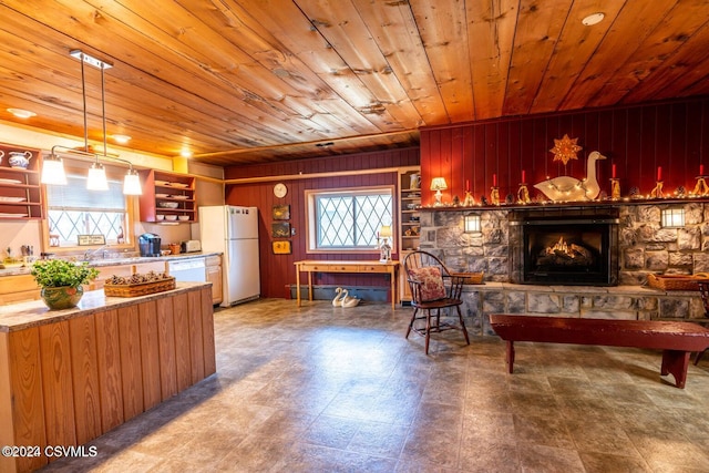 kitchen with wood walls, wooden ceiling, decorative light fixtures, and white refrigerator