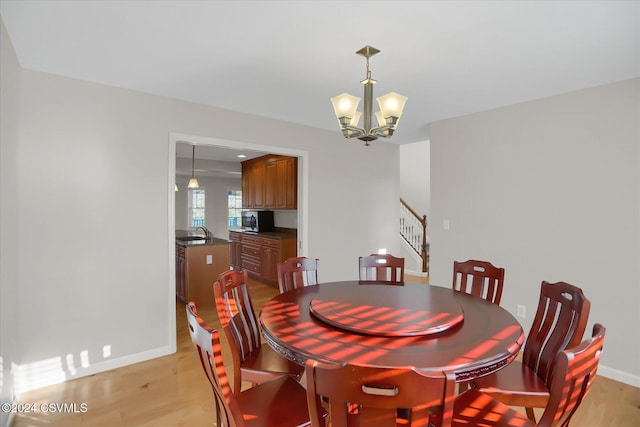 dining area featuring light hardwood / wood-style floors, sink, and a chandelier