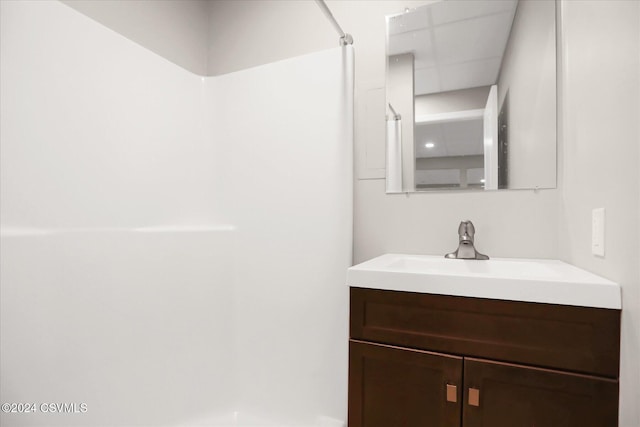 bathroom featuring walk in shower and vanity