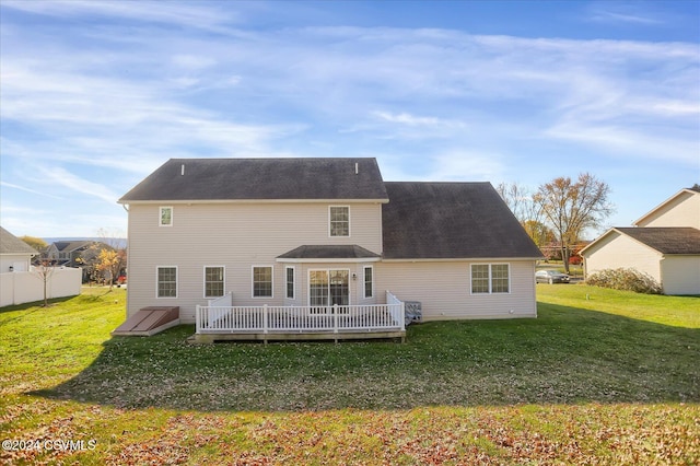 rear view of property with a deck and a yard