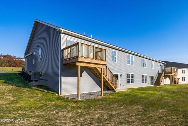 back of house featuring a wooden deck, central AC, and a lawn