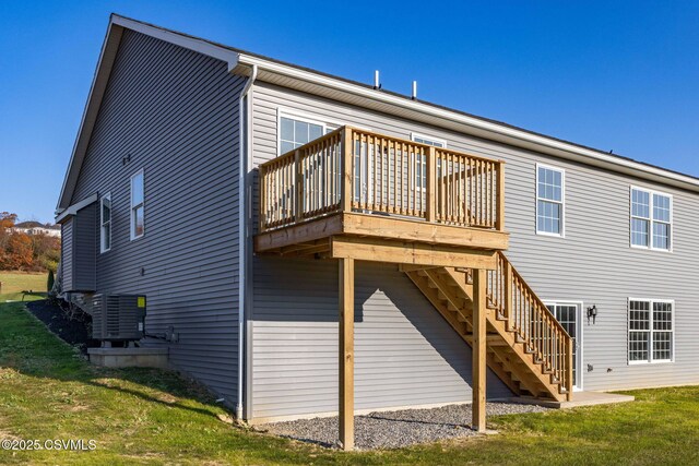 back of property with a yard, central air condition unit, and a deck