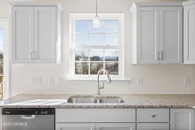 kitchen featuring decorative light fixtures, sink, white cabinets, stainless steel dishwasher, and light stone countertops