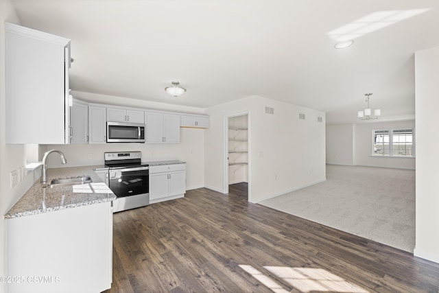 kitchen with appliances with stainless steel finishes, white cabinetry, sink, light stone countertops, and dark wood-type flooring