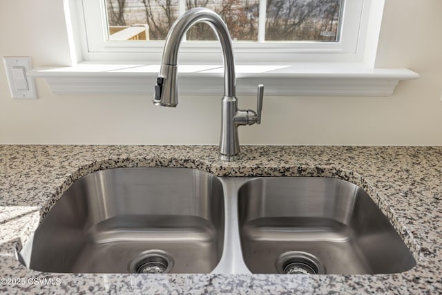 interior details with light stone countertops and sink