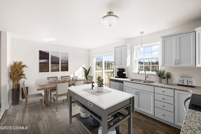 kitchen featuring sink, decorative light fixtures, dark wood-type flooring, and stainless steel dishwasher