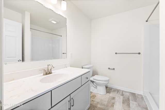 bathroom with vanity, toilet, and a shower