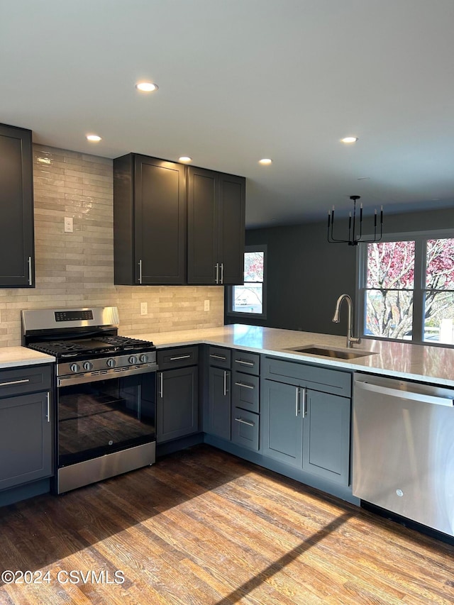 kitchen featuring decorative backsplash, sink, light wood-type flooring, and appliances with stainless steel finishes