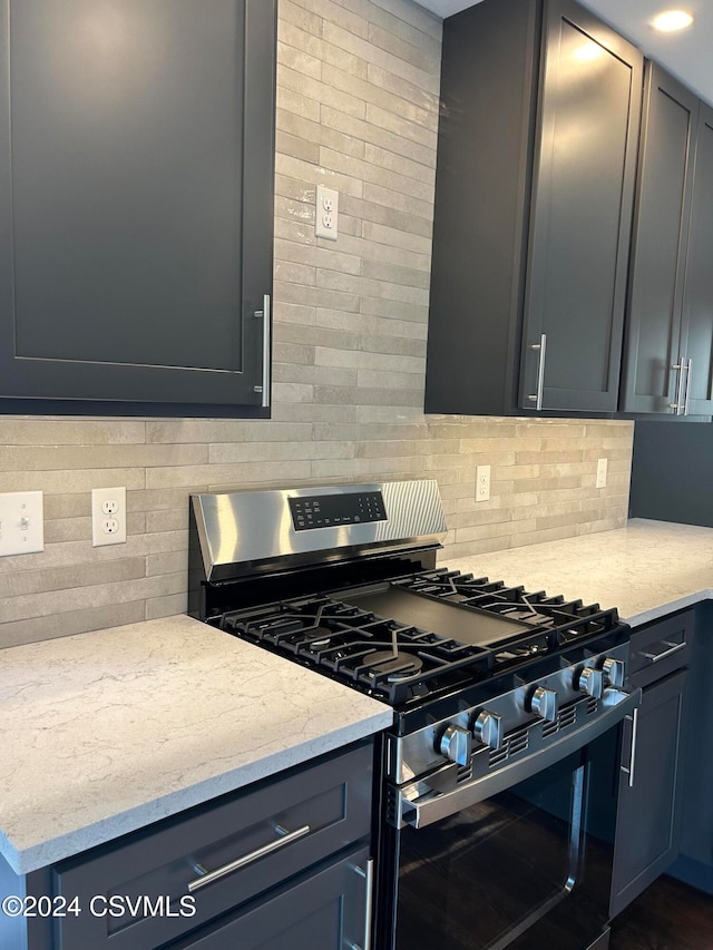 kitchen with light stone countertops, tasteful backsplash, and stainless steel range with gas stovetop