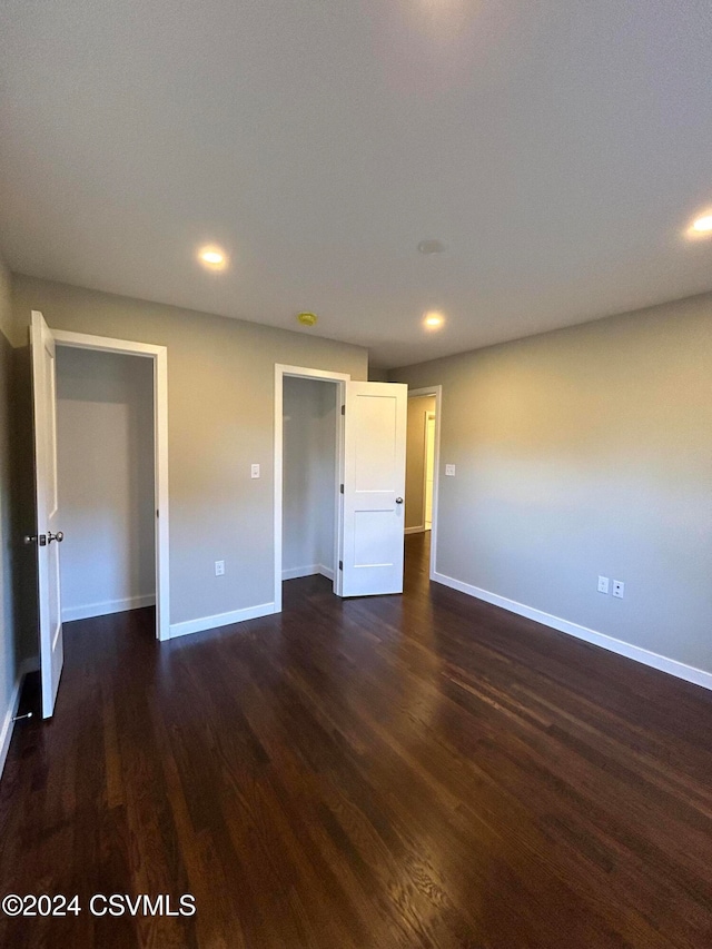 unfurnished bedroom with dark wood-type flooring