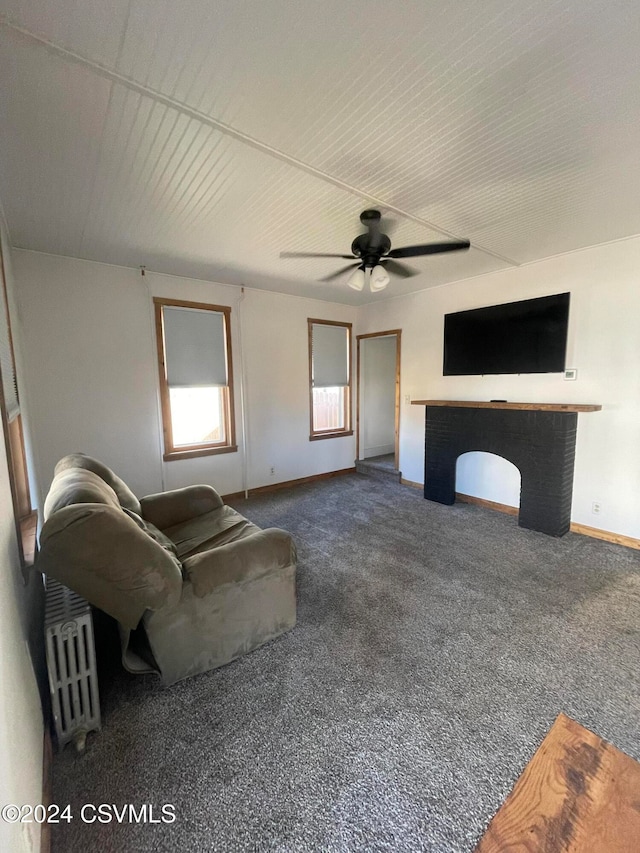 unfurnished living room with ceiling fan and carpet