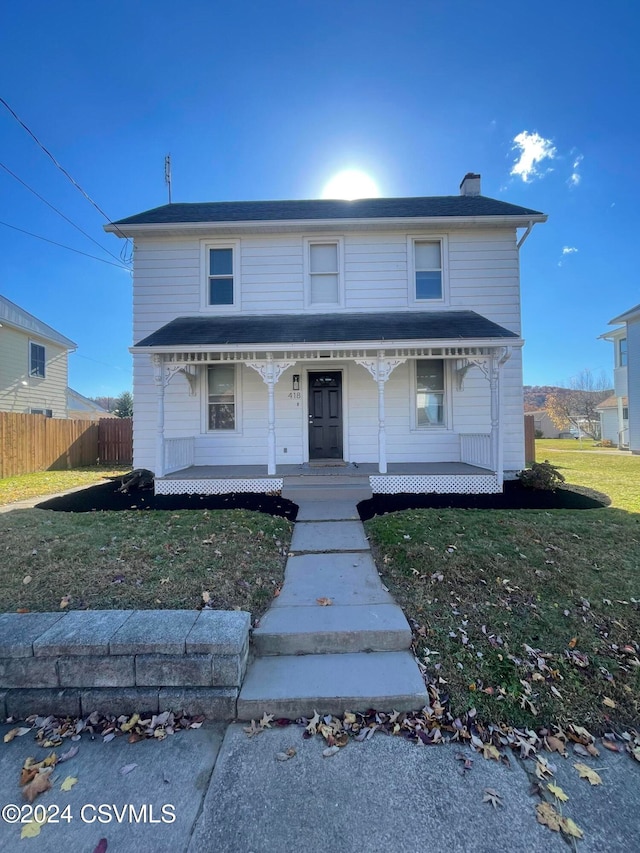 view of front facade featuring covered porch and a front yard