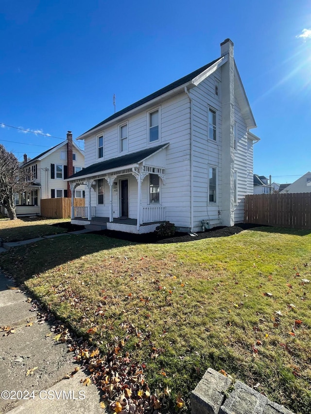 view of front of house with covered porch and a front lawn