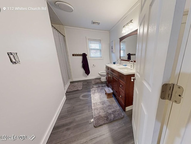 bathroom featuring toilet, crown molding, hardwood / wood-style floors, and vanity