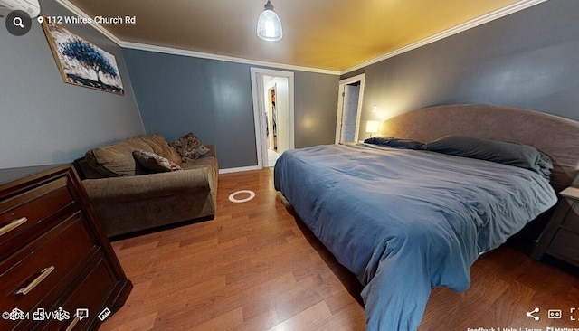 bedroom featuring crown molding and wood-type flooring