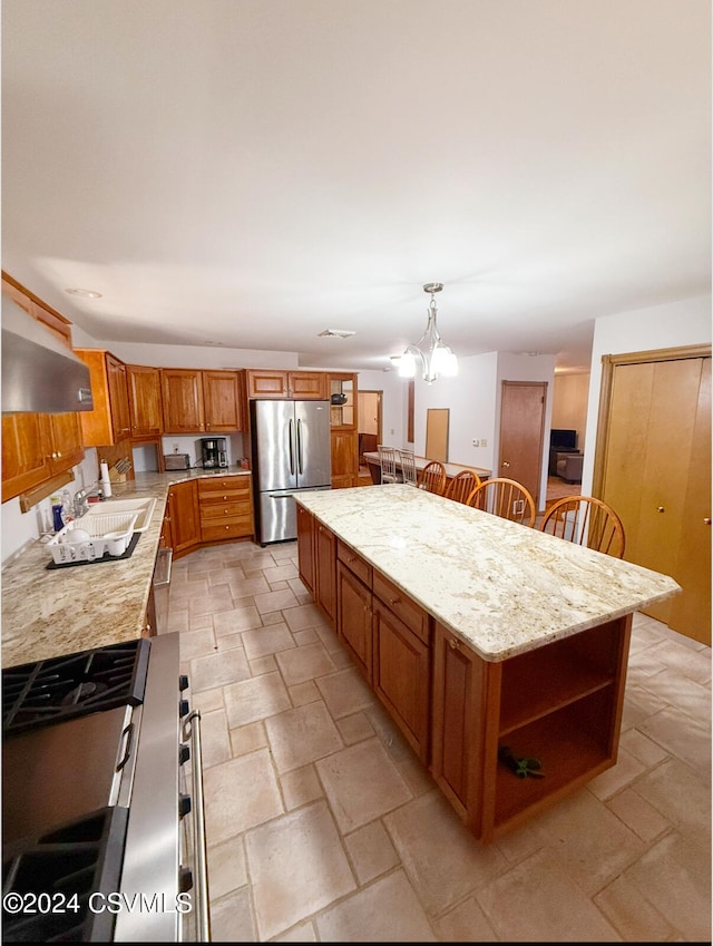 kitchen featuring stainless steel appliances, a breakfast bar, a chandelier, a center island, and pendant lighting