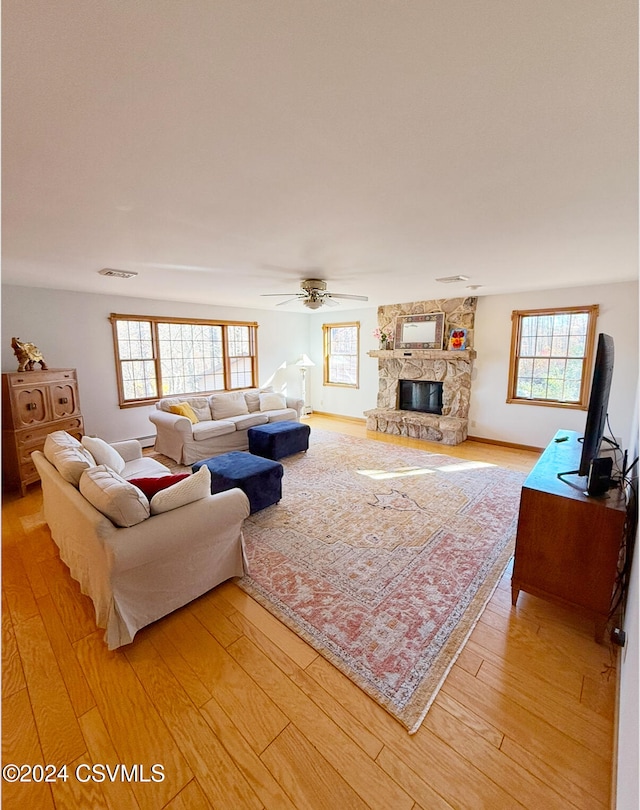 living room featuring light hardwood / wood-style floors, ceiling fan, and a healthy amount of sunlight