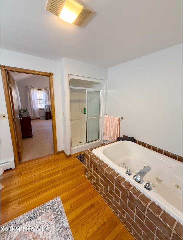 bathroom featuring baseboard heating, independent shower and bath, and hardwood / wood-style flooring