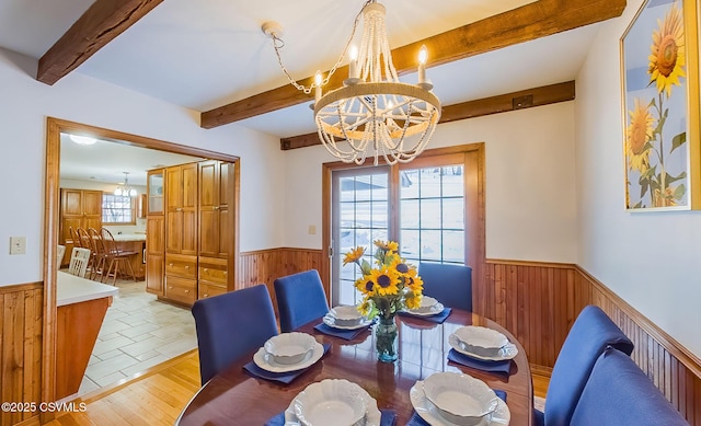 tiled dining room with beamed ceiling and an inviting chandelier